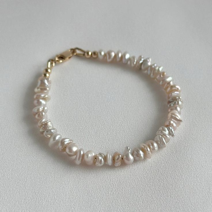 Elevate your bridal ensemble with our exquisite Keshi Pearl bridal bracelet. This stunning piece features irregular freshwater pearls that exude timeless elegance and charm. Every gemstone is meticulously handcrafted to create a unique and eye-catching design, making it the perfect accessory for your special day. As the June birthstone and ideal for a 30th wedding anniversary gift, this bracelet is a meaningful token of love and appreciation for her. Give her a gift she will cherish forever with Baroque Pearl Bracelets For Wedding, Baroque Pearl Wedding Bracelets, Elegant Baroque Pearl Bracelet For Wedding, Wedding Baroque Pearl Chain Bracelet, Dainty Baroque Pearl Bracelet For Wedding, Delicate Baroque Pearl Jewelry For Anniversary, Pearl Oyster Bracelet For Anniversary, Pearl White Beaded Bracelets With Pearl Chain For Anniversary, Adjustable Pearl Bracelet For Anniversary