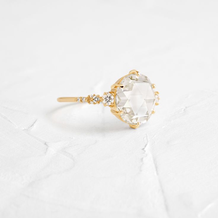 Round rose cut diamond focal (4.34ct., VS1 clarity, I color)— View the IGI certificate for this piece here! The diamond in the photo is the stone you will receive. This ring is one of a kind and features a closed basket setting with six prongs on a delicate 1.2mm band of 14k yellow gold. The band is accented by sixteen (1-2.5mm) round white diamonds, eight on each side of the focal stone. All accent diamonds are SI clarity and G+ color. We handcraft each piece with responsibly sourced metals and Melanie Casey, Fulfilled Life, Glowing Face, Basket Setting, The Mundane, The Quiet, Rose Cut Diamond, White Diamonds, Rose Cut