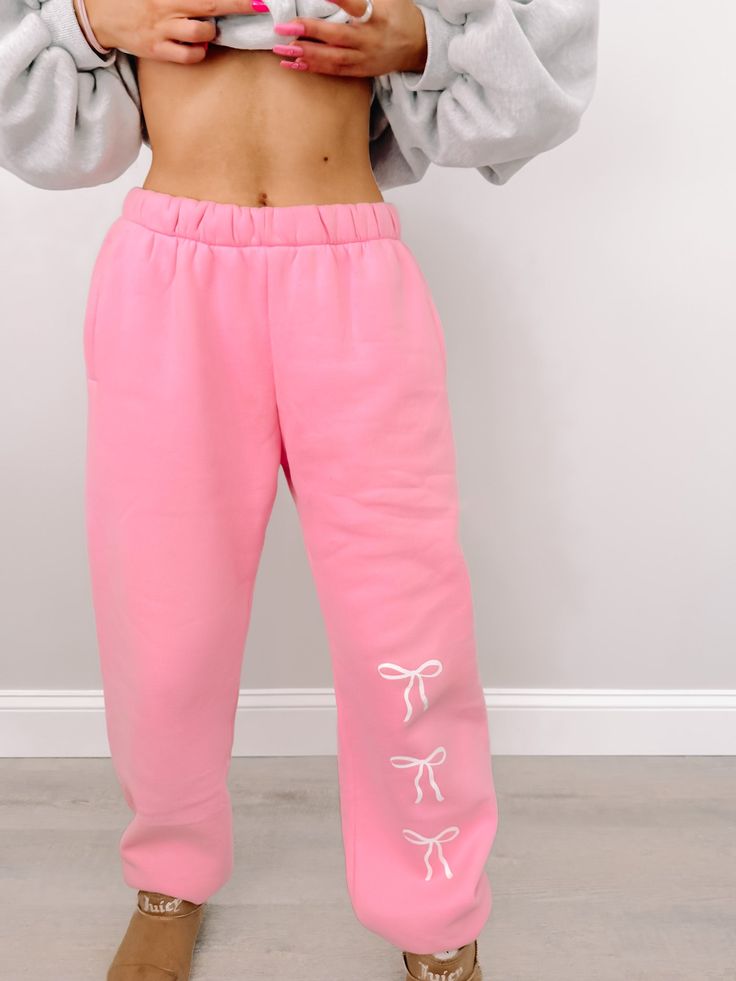 We are so excited to release our newest Sassy Shortcake merch item! The Blushing Bow Sassy Sweatpants are pink and feature three white bows text. These sweats feature an elastic waistband and pockets for maximum comfort, and feature a soft micro-fleece lining. Rep your favorite brand in these super cute pants!! Also available in blue and grey. fits: true to size, model wearing a size small content: 100% polyester care: hand wash cold Pink Drawstring Sweatpants For Loungewear, Pink Athleisure Joggers With Drawstring, Pink Drawstring Casual Joggers, Pink Casual Joggers With Drawstring, Pink Drawstring Loungewear Pants, Pink Drawstring Lounge Pants, Pink Drawstring Pants For Loungewear, Pink Drawstring Sweatpants For Leisure, Trendy Pink Sweatpants With Drawstring