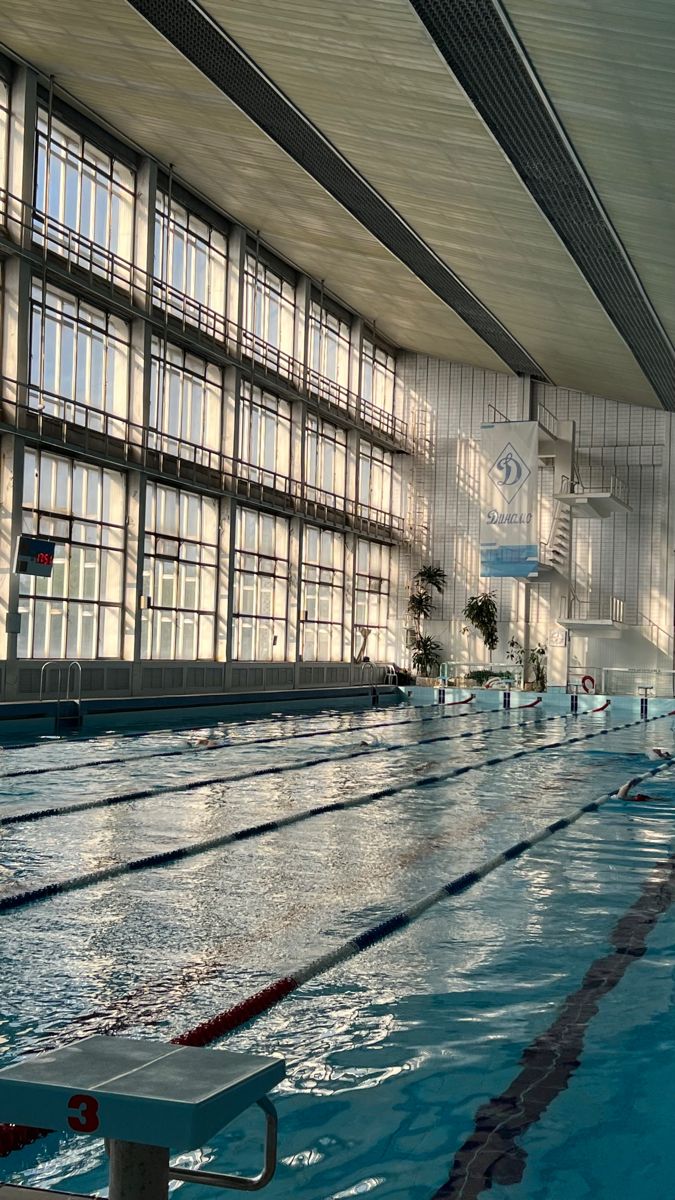 an empty swimming pool with no people in it and windows on the wall above them