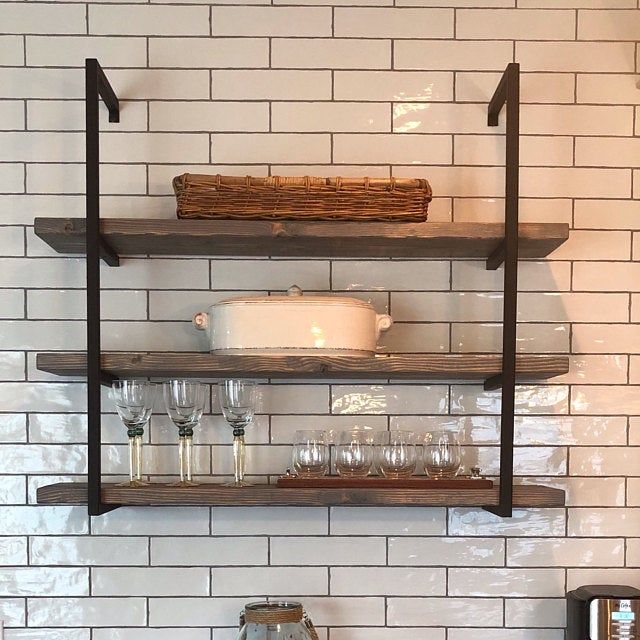 the shelves in the kitchen are filled with dishes and wine glasses, along with other utensils