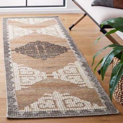 a large rug is on the floor in front of a chair and window with a potted plant next to it