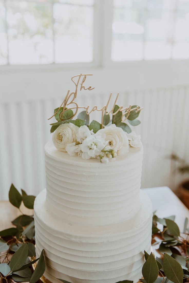 a wedding cake with white flowers and greenery