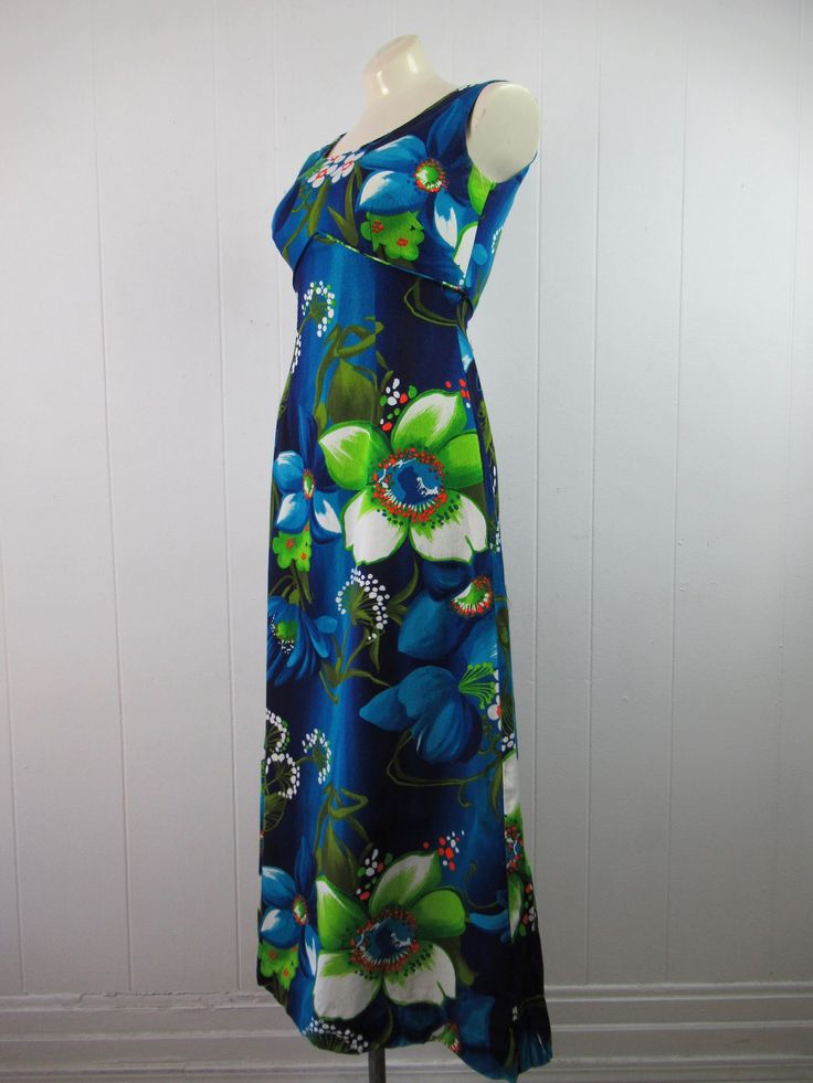 "Vintage 1960s Hawaiian dress. Made of blue cotton with floral pattern. Has empire waist and back zipper. Made ands styled in Hawaii by Royal Hawaiian. About a size small. Measurements are: 35\" around the bust 25\" around the waist 37\" around the hips 14.5\" shoulder to shoulder 51\" overall length In very good condition." Retro Blue Spring Maxi Dress, Retro Blue Maxi Dress For Spring, Blue Lined Maxi Dress For Garden Party, Retro Blue Maxi Dress For The Beach, Blue Retro Maxi Dress For Summer, Retro Blue Maxi Dress For Summer, 1970s Style Blue Floral Print Dresses, Blue Retro Dress For Garden Party, Retro Blue Dress For Garden Party