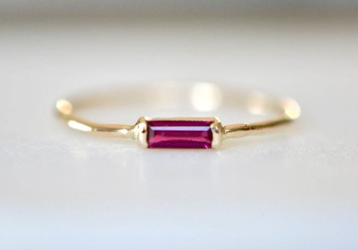 Stunning red ruby is set in solid 14k gold. A solid gold band makes this suitable for everyday wear. Great as a gift to yourself or a loved one. *Made to Order. If you would prefer the use of an earth mined ruby please convo me. ◈ Gemstone : Lab Created Ruby ◈ Ring Thickness: ~ 1 mm ◈ Gem Dimensions: 4x2mm ◈ Cut: Baguette ◈ Metal: 14K Solid Gold (18K also available - please convo me for a quote) ◈ Gold Color: Choose from dropdown Packaging : All products purchased from us come in a gift box. If Rectangular Ruby Ring, Minimalist 14k Gold Red Ruby Ring, Art Deco Engagement Rings, Graduation Ring, Graduation Rings, Ruby Rings, Baby Rings, Future Engagement Rings, Ruby Diamond Rings