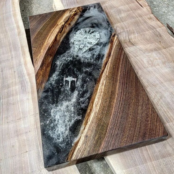 a piece of wood sitting on top of a wooden table covered in black and white marble