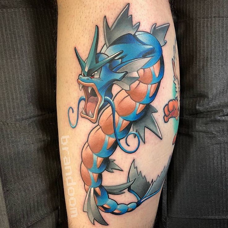 a person with a tattoo on their leg that has an image of a blue and orange dragon