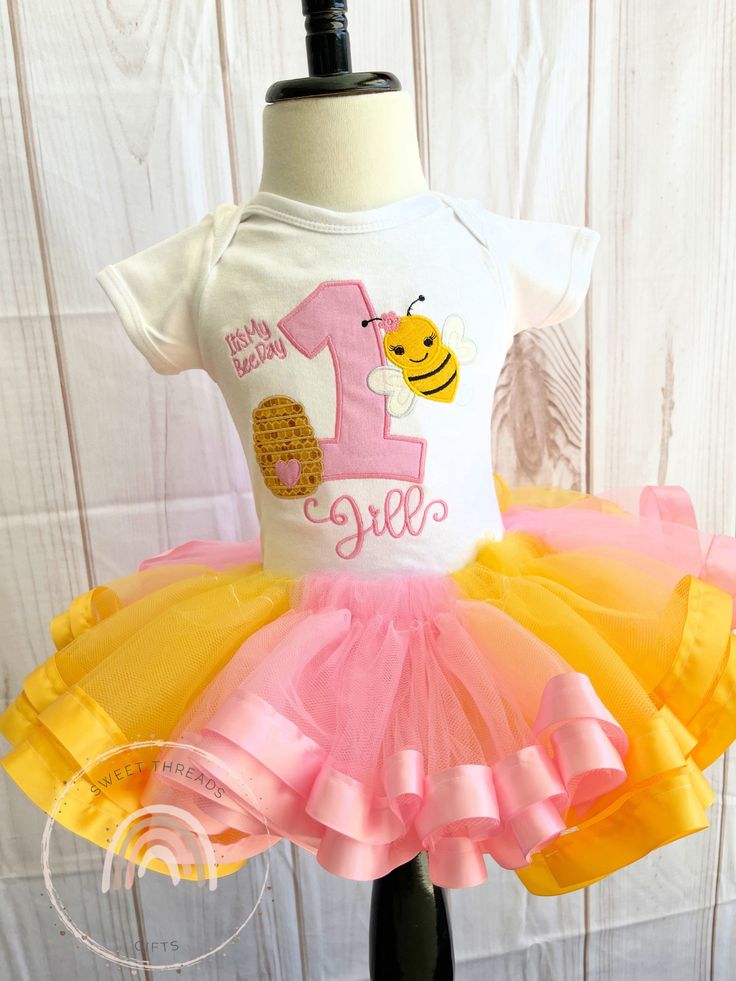 Bumble Bee Tutu Outfit, Bee Birthday Shirt, Bumble Bee Birthday Tutu Outfit, Bee Birthday party outfit, Ribbon Trim Tutu Outfit  Processing time does not include shipping which is USUALLY an additional 4-7 days with First Class shipping. If needed sooner a rush upgrade can be chosen from the Upgrade section in the store for an additional cost. Other shipping options are available in the Rush My Order section in my shop. Please message me first.  This is a boutique quality T-shirt that runs true to size. Please see the size chart in the photos. The shirts are thick and very soft in sizes 12 months to size 14. I cover the the back of the stitching with a soft stitch cover. All body suits are Creations Of Grace brand. They are nice and thick and fit true to size. I cover the the back of the s Bumble Bee Birthday, Ribbon Trim Tutu, Birthday Party Outfit, Bee Birthday Party, Birthday Tutu Outfit, Bee Birthday, Birthday Party Outfits, Body Suits, Thick And Fit