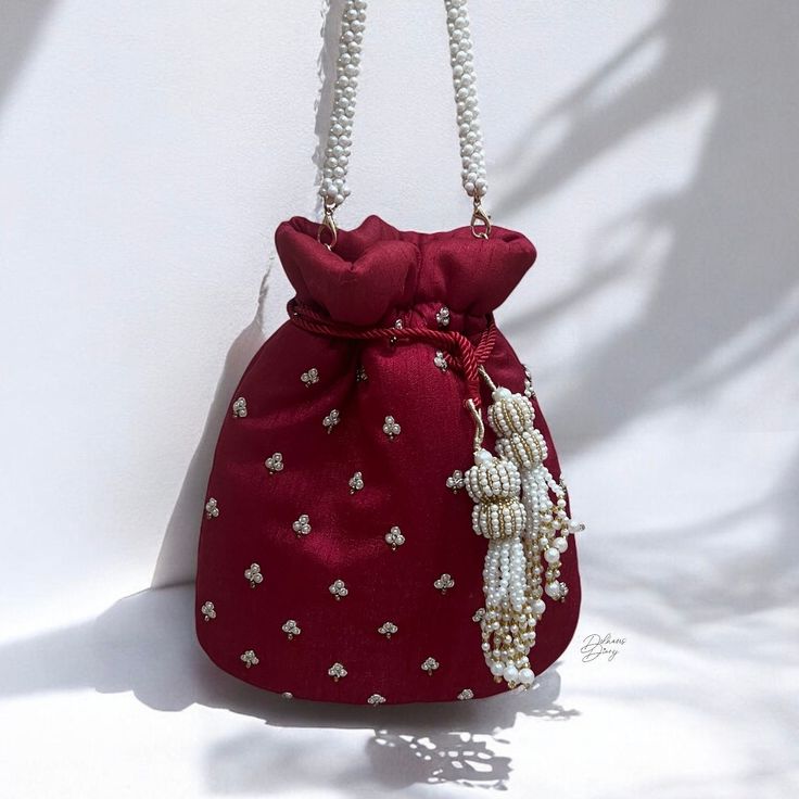 Elevate your bridal ensemble with our exquisite deep red Bridal Wedding Day Potli Bag. Crafted from luxurious raw silk fabric, adorned with intricate zardozi and beadwork, this potli bag exudes elegance and opulence. The delicate beadwork on both side of bag adds a touch of glamour, while the beautiful log tassels enhance its regal charm. This potli bag is the perfect accessory to complement your bridal look, adding a timeless allure to your special day. Product Details: *Handmade with traditional Pakistani and Indian techniques *Spacious interior  *Measures 7 inches To explore additional styles, kindly visit our website at dulhansdiary.etsy.com. . . . . . . #deepredpotli #handmadeclutch #bridalhandbag #weddingaccessories #ethnicbag #uniquegift #artisanmadeclutch #punjabiclutches #potlibag Indian Potli Bags, Elegant Festival Potli Clutch Bag, Elegant Festival Clutch Potli Bag, Red Embroidered Potli Bag For Party, Festive Beaded Evening Bag As Gift, Festive Beaded Evening Bag For Gift, Elegant Red Evening Pouch, Red Shoulder Bag For Festive Gift, Festive Red Shoulder Bag As Gift