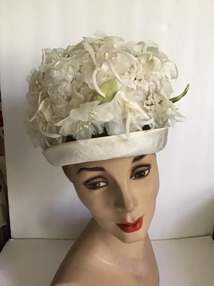 "Vintage 1960's hat. White floral with Green leaves bucket style hat. The label is *SEARS Fashion Millinery*. Sears Roebuck and Co. USA. *MORE INFORMATION BELOW* CONDITION: No issues noted. MEASURES: Inside circumference~21 1/2\" Height~5\" Front to back~8\" Left to right~7\" *WE APOLOGIZE~BUT WE NO LONGER SHIP TO GERMANY, ITALY OR SPAIN. IF ORDERS COME IN FROM GERMANY, ITALY OR SPAIN, WE WILL HAVE TO CANCEL THEM AND REFUND YOUR MONEY. SORRY FOR THIS INCONVENIENCE*" Vintage White Cloche Hat, Vintage Cream Mini Hats With Curved Brim, White Vintage Cloche Fascinator, Vintage Cream Mini Hat With Curved Brim, Vintage White Cloche Fascinator, Vintage Cream Mini Hat For Church, Vintage Cream Fascinator With Short Brim, Vintage Cream Costume Hat With Curved Brim, Vintage White Fascinator Hat