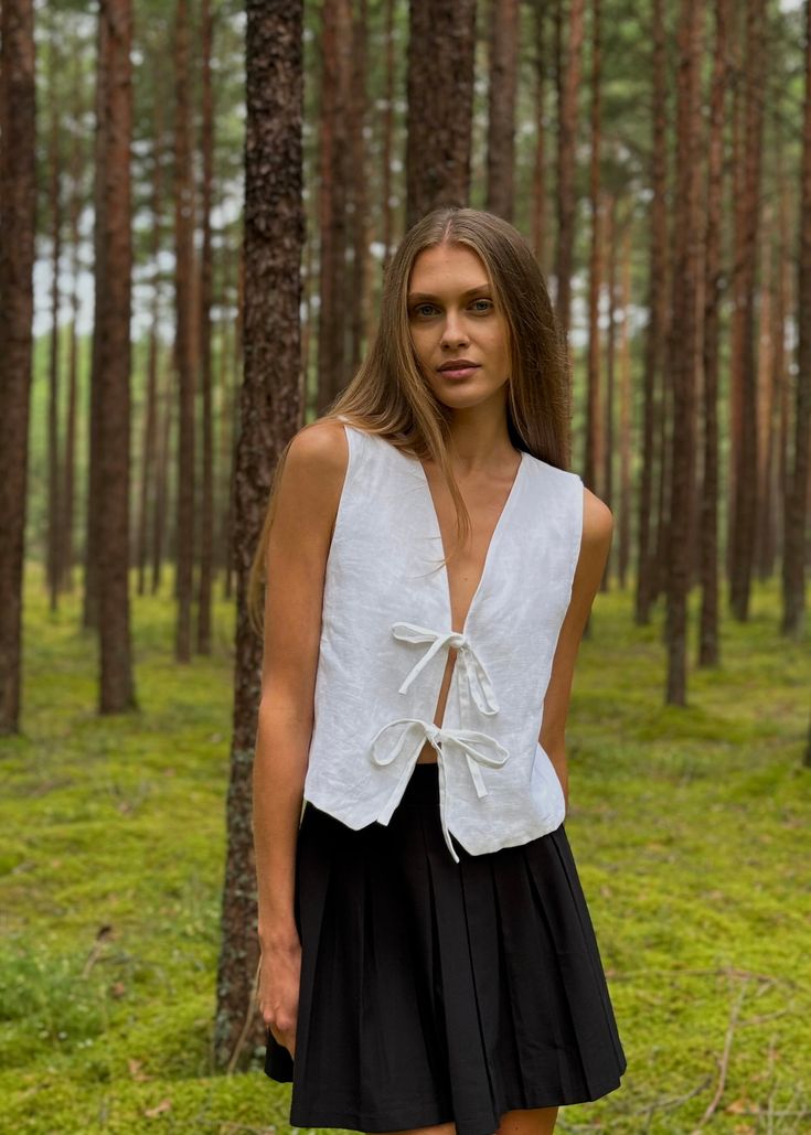 We're thrilled to introduce our summer's hottest drop: the Linen Vest with Front Ties. This versatile and feminine linen top adds a touch of class and romance to any outfit, effortlessly pairing with pants, skirts, shorts, or even jeans. Made from 100% OEKO-TEX-certified linen, our vest is incredibly comfortable and breathable, keeping you cool and stylish all season long. DETAILS: - Two Front Ties - V neck  - Relaxed Fit  - Customization available: We can shorten front ties upon request - European Linen (OEKO-TEX certified)  - Hand Made in our small studio in Siauliai, Lithuania - Made-to-order (To minimize waste, we craft our linen vests on demand. Allow 2-3 business days for us to sew your vest)  SIZE IN THE PICTURE:  Model is 5'8"/ 176cm height and wears size S  GARMENT SIZE CHART: *Pl Linen Vest Top, White Linen Vest Outfit, Wrap Vest Pattern, Siauliai Lithuania, Tie Front Vest, Wrap Top Pattern, Linen Wrap Top, Vest Sewing Pattern, Oversized Linen Shirt