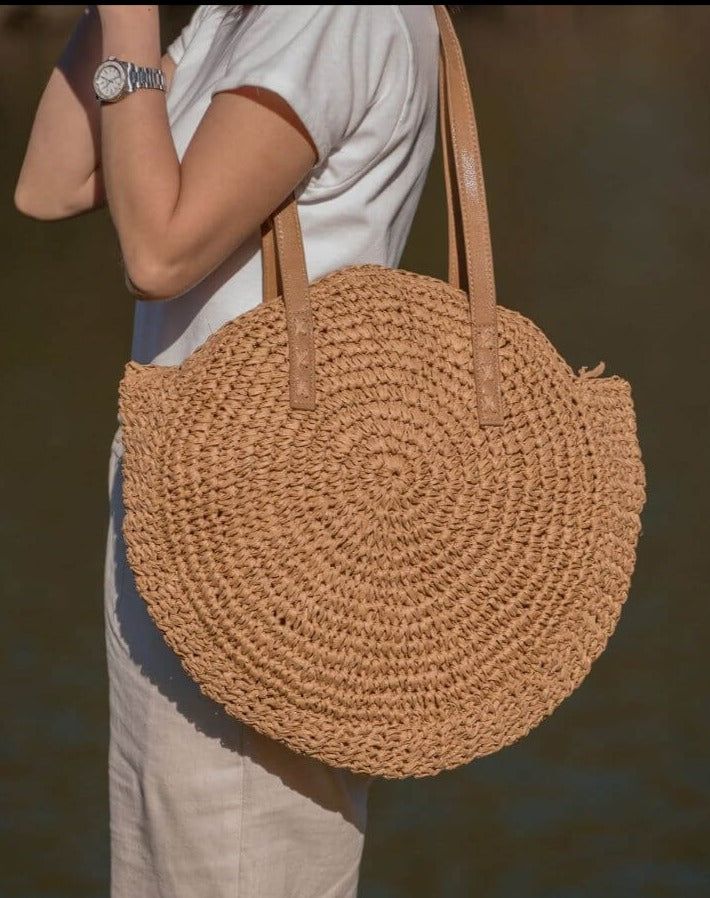 Introducing our Round Straw Bag - the epitome of boho chic and beach vibes. This rattan beach tote bag, also known as the Bali Bag, is the perfect accessory to elevate your style and bring a touch of bohemian charm to any outfit. Shape and Style: The bag's round shape adds a unique and trendy element to your look, making it a standout piece wherever you go. Its boho-inspired design is perfect for beach days, vacations, or casual outings, giving you that relaxed and carefree feel. Versatile Shoul Bohemian Lightweight Beach Bag For Vacation, Lightweight Brown Bohemian Beach Bag, Bohemian Lightweight Jute Beach Bag, Bohemian Lightweight Crochet Beach Bag, Chic Beach Bag Made Of Natural Fiber, Bohemian Lightweight Beach Bag In Natural Color, Chic Summer Bags Made Of Natural Fiber, Lightweight Bohemian Brown Straw Bag, Spring Travel Beach Bag Made Of Rattan