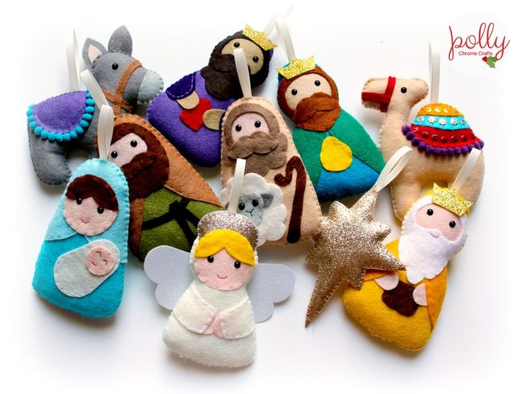 small felt nativity ornaments are displayed on a white surface