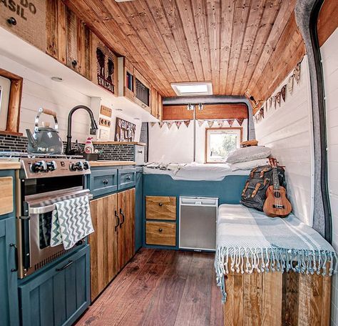 the interior of a tiny home with wood flooring and blue cabinets, including an oven