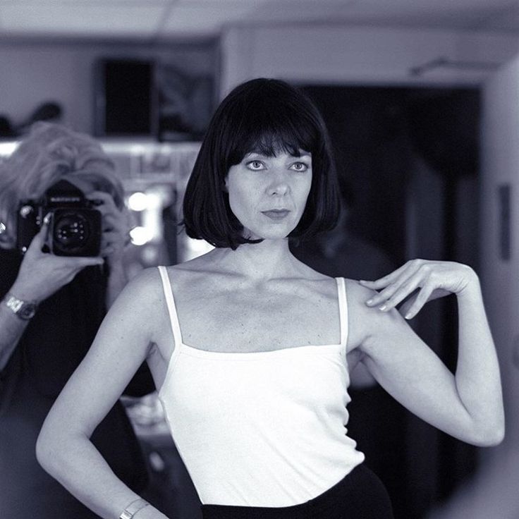 a woman taking a selfie in front of a mirror with her hand on her hips