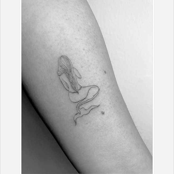 a black and white photo of a woman's arm with a tattoo on it