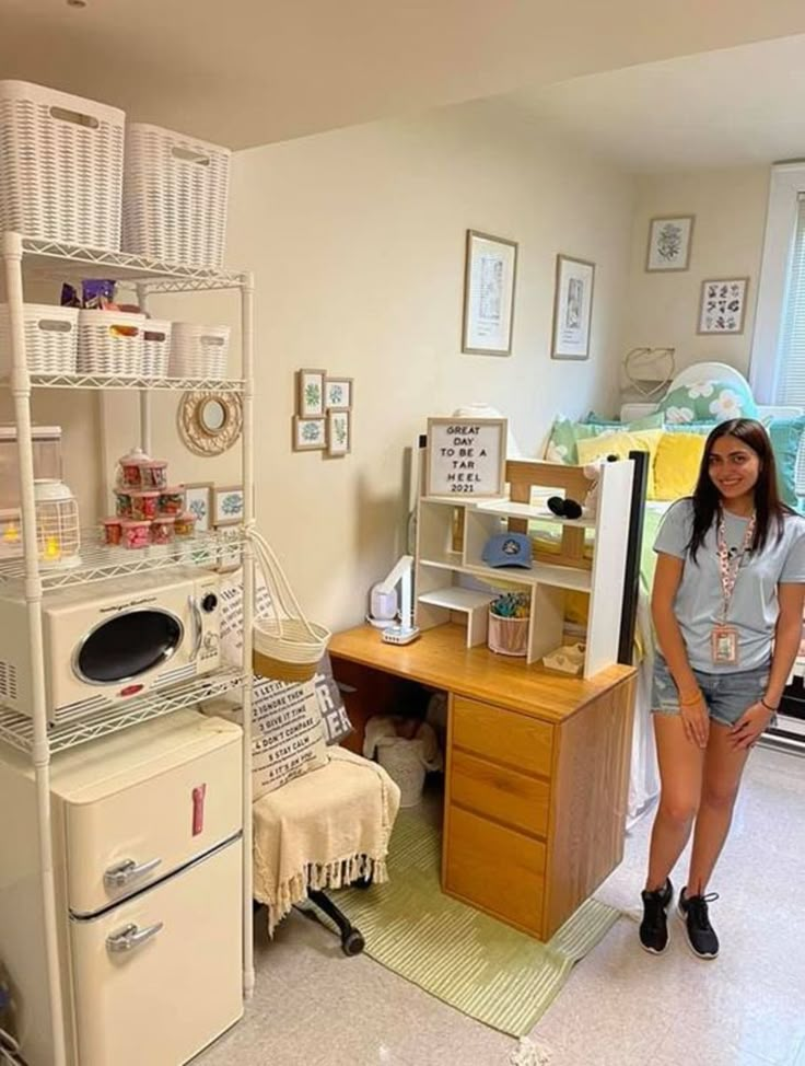 a woman standing next to a desk in a room filled with furniture and other items