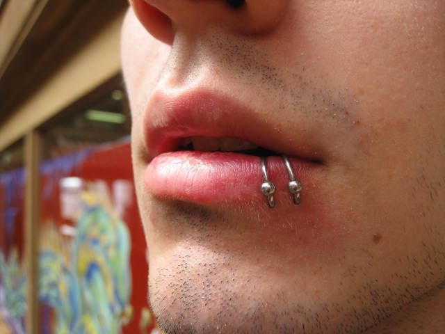 a man with piercings on his nose looking at the camera