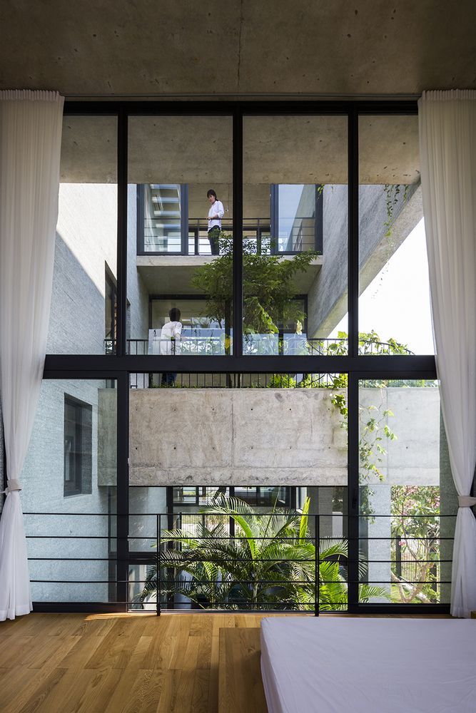 a bedroom with wooden floors and large windows