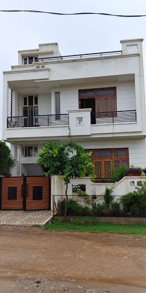 a large white building with two balconies on the second floor and one story