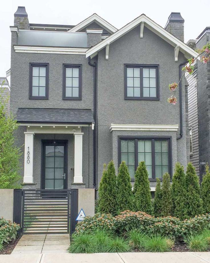 a gray house with white trim and black shutters on the front door is featured in an instagram