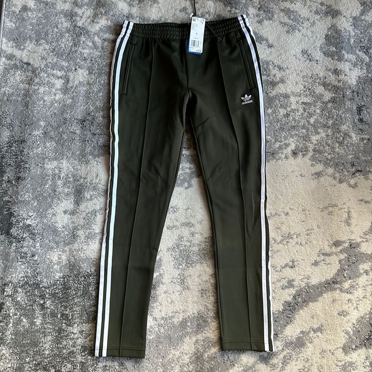 Super Cute Olive Green New Adidas Sst Womens Track Pants Green Athleisure Bottoms With Side Stripes, Casual Green Bottoms With Three Stripes, Spring Stretch Pants With Side Stripes, Adidas Stretch Pants With Three Stripes, Casual Adidas Stretch Pants, Casual Fitted Bottoms With Side Stripes, Fitted Casual Bottoms With Side Stripes, Adidas Stretch Sweatpants For Spring, Green Adidas Cotton Bottoms