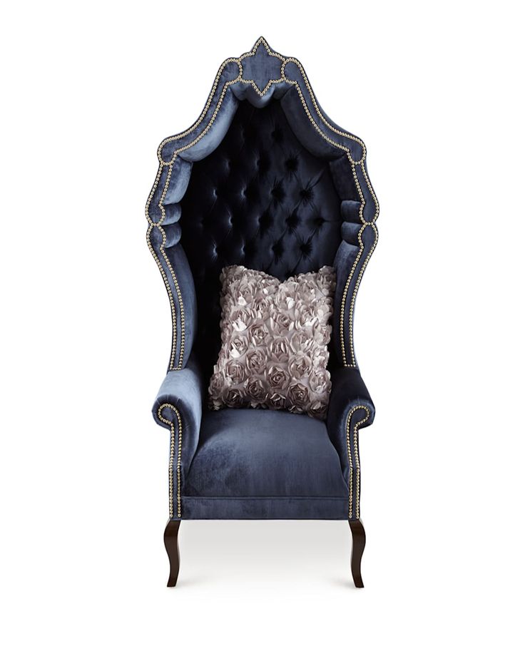 a blue chair with a silver pillow on it's back and an intricately decorated arm