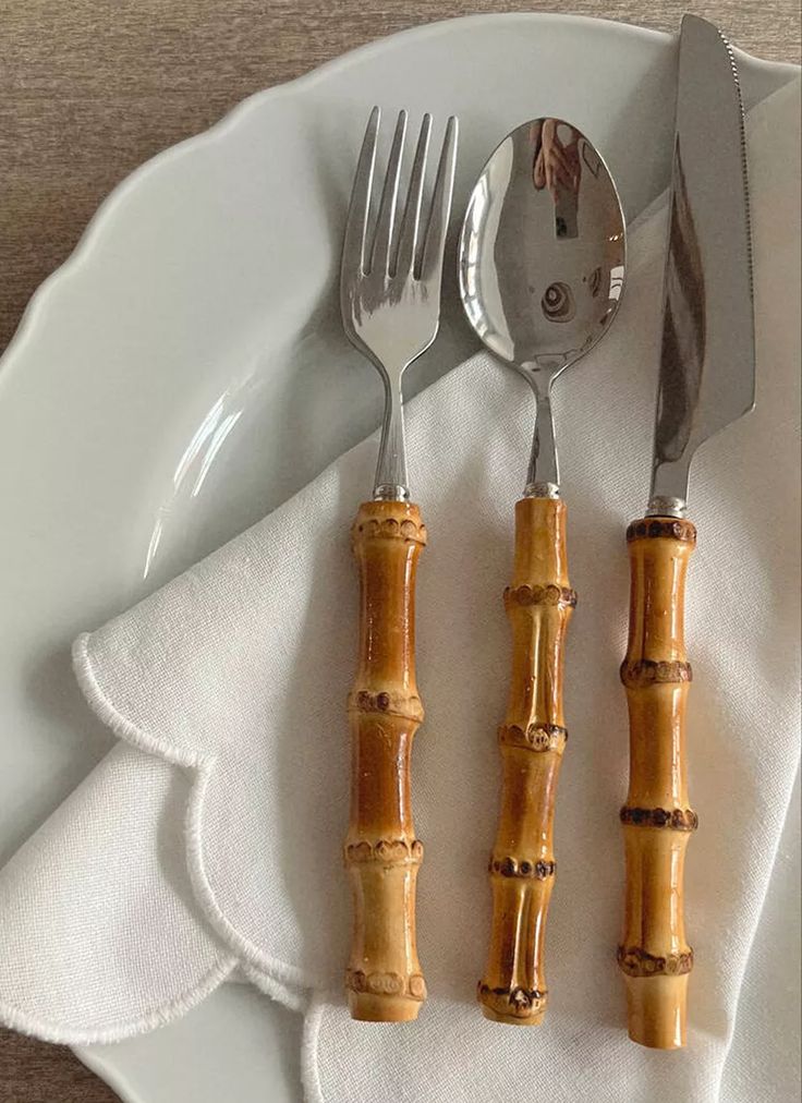 two forks and spoons on a white plate with bamboo sticks in the shape of utensils