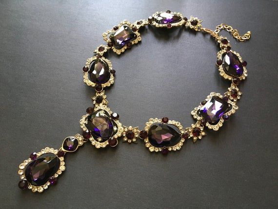 Featuring clear/pink rhinestones crystals and purple glass stones and linked to cable chain.Just elegant and romantic!!Color: antiqued brass with clear/pink rhinestones crystals and purple glass stones   Size: necklace measures around 21” long x 1.15” width x 2.5 center drop ** Please note we need to take around 5 days to make it.  Please be patient. **Item ship out with tracking number to you (around 10 to 14 business days for delivery).We also provide fast shipping service, around 3-4 business Party Crystal Necklaces With Gemstone Accents, Elegant Purple Crystal Necklace With Gemstone Accents, Elegant Jeweled Crystal Necklaces For Formal Occasions, Glamorous Jeweled Crystal Necklace For Gift, Glamorous Jeweled Crystal Necklaces For Gifts, Elegant Jeweled Crystal Necklace For Formal Occasions, Purple Jewelry With Sparkling Stones For Party, Crystal Jeweled Necklace For Wedding, Elegant Jeweled Crystal Necklaces For Wedding