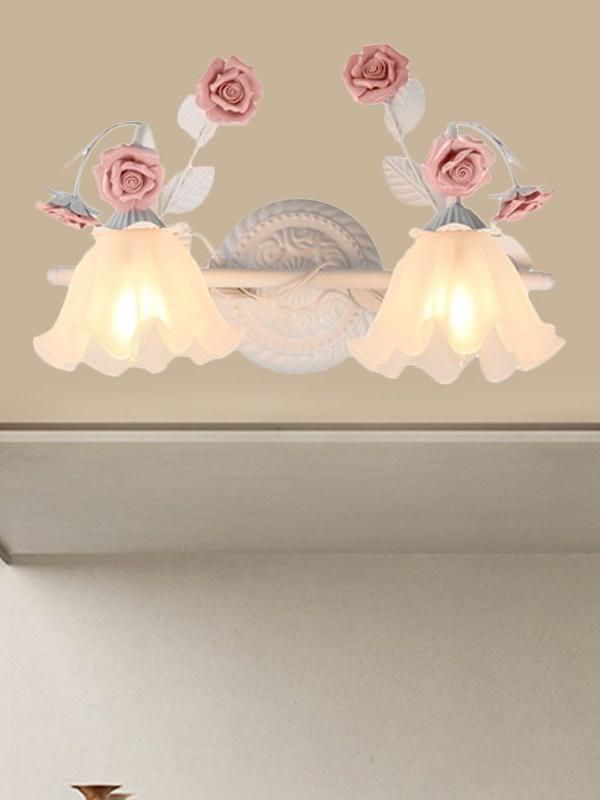 three pink roses are hanging from a light fixture in a room with beige walls and flooring