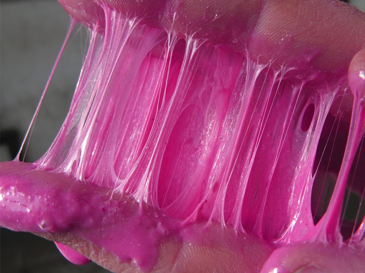 a person is holding some pink toothpaste in their hand and it looks like they are dripping