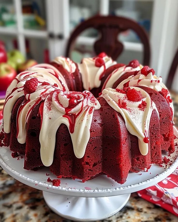 a red velvet cake with white frosting and raspberry toppings on a plate