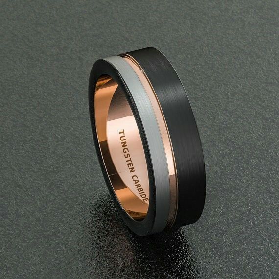 a black and gold wedding band with an inscription engraved on the side, in two tone