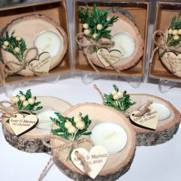 four wooden slices with candles and greenery on them are arranged in the shape of hearts