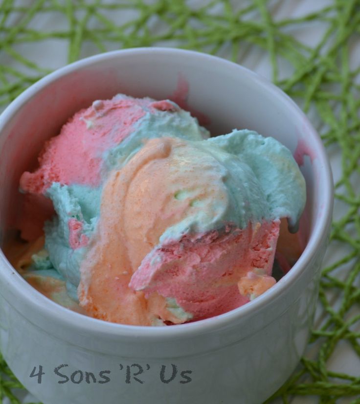 three scoops of ice cream in a white bowl with green grass on the side