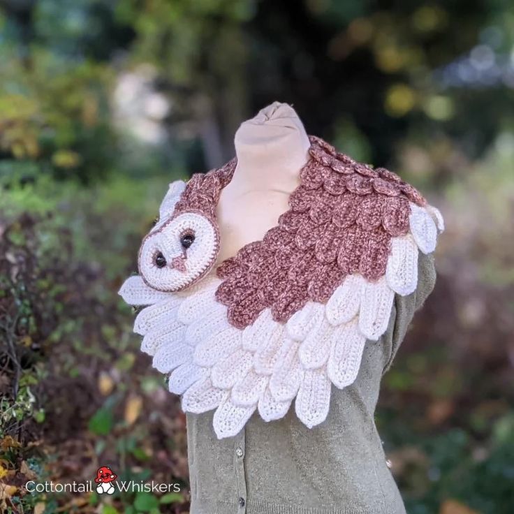 an owl scarf is shown on top of a mannequin's head in the woods