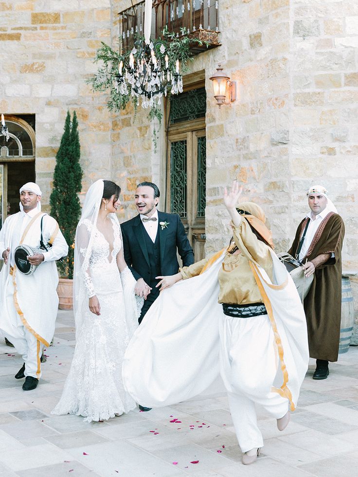 a bride and groom are walking through the courtyard