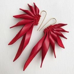 two pairs of red leather earrings on white background