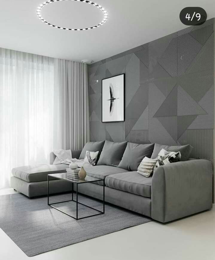 a modern living room with grey walls and white curtains on the window sill,