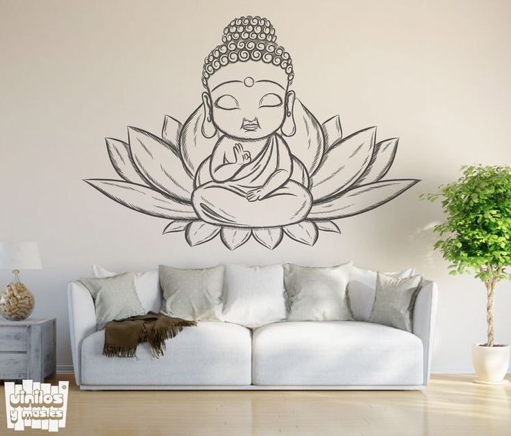 a buddha statue sitting on top of a white couch next to a potted plant