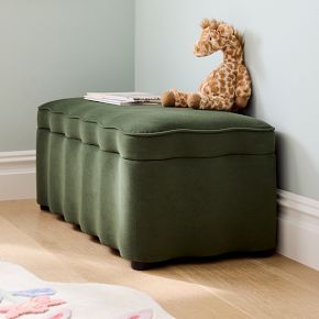 a giraffe stuffed animal sitting on top of a green storage bench in a child's room