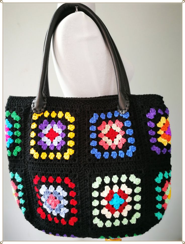 a black crocheted bag with multicolored squares on it's sides