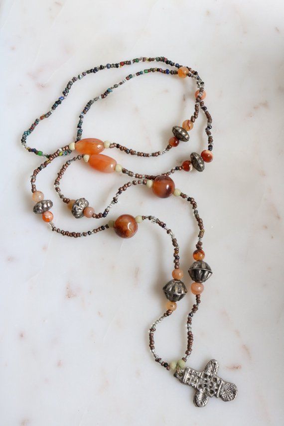 Vintage beaded cross necklace with natural agate stones.Length (Doubled):  18"Pendant length: 1 1/4"Weight: 28.7 gramsGood vintage condition!For more necklaces:https://www.etsy.com/shop/SusVintage?ref=l2-shopheader-name§ion_id=14148238For more jewelry please visit my website:https://www.aiamou.comBack to the shop:https://www.etsy.com/shop/SusVintage?ref=hdr_shop_menuDon't hesitate to contact me if you have any further questions.Thank you for looking!! Long Agate Beaded Necklace With Polished Beads, Bohemian Silver Beaded Necklaces With Carnelian, Silver Carnelian Beaded Necklace With Gemstone Beads, Brown Carnelian Beaded Necklace With Large Beads, Artisan Brown Carnelian Beaded Necklaces, Artisan Carnelian Beaded Necklace, Artisan Brown Carnelian Beaded Necklace, Brown Carnelian Large Beaded Necklace, Silver Beaded Carnelian Necklaces