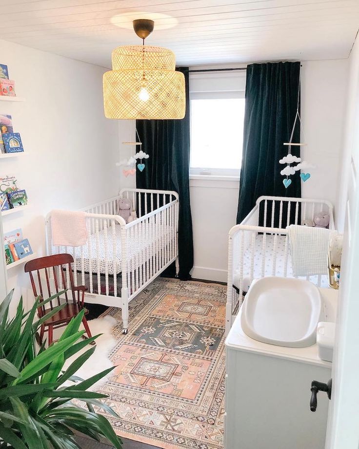 a baby's room with two cribs and a rug