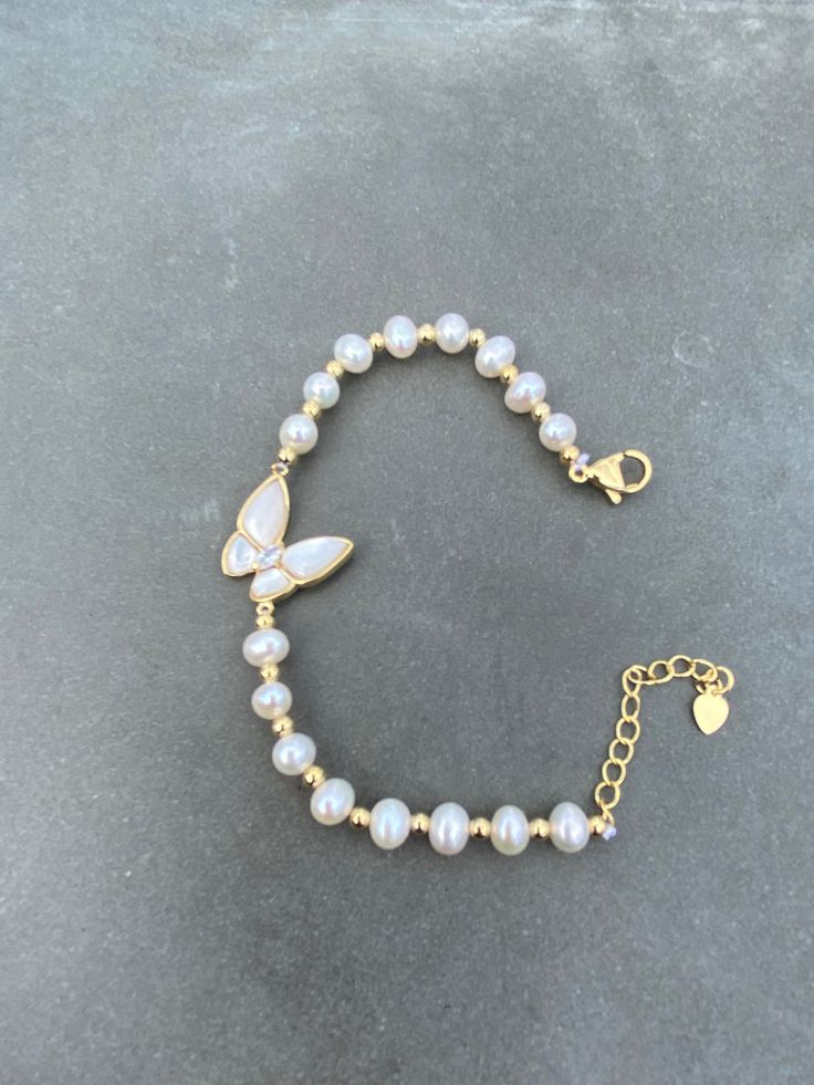 Elevate your jewelry collection with this stunning beaded bracelet featuring beautiful freshwater pearls and a delicate mother-of-pearl butterfly charm. Crafted from high-quality 14k yellow gold plated metal, this bracelet exudes a timeless elegance that's perfect for any occasion. The white pearls and secondary pearl stones add a touch of sophistication to the piece, making it a must-have for any fine jewelry lover. The bracelet is designed in a versatile beaded style, making it easy to pair wi Feminine Pearl Bracelets As Gift, Elegant Pearl Beaded Charm Bracelet, Feminine Pearl Bracelet For Gifting, Elegant Butterfly Bracelets For Gifts, Elegant Butterfly Bracelets For Gift, Delicate Beaded Bracelets With Pearl Charm As A Gift, Delicate Beaded Bracelets With Pearl Charm For Gift, Feminine Pearl Charm Bracelet As Gift, Delicate Beaded Bracelet With Pearl Charm For Gift