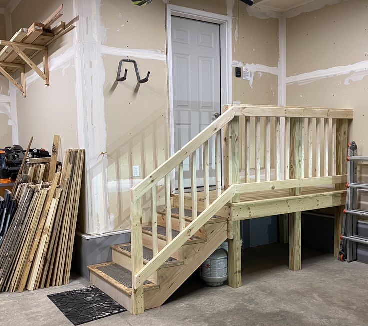 there is a wooden staircase in the middle of a room with unfinished walls and flooring