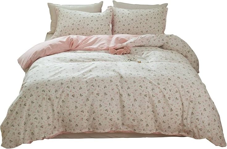 the comforter is made up with pink and white flowers on it's bed