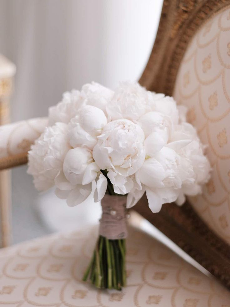 a bouquet of white flowers sitting on top of a chair