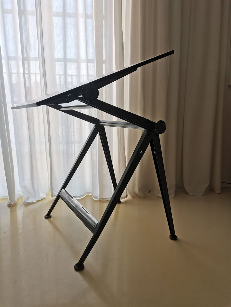 a bike frame sitting on top of a wooden floor in front of a white curtain