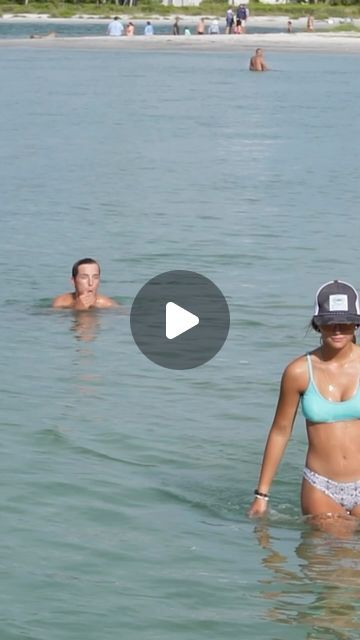 two people are in the water and one person is wearing a hat with no shirt